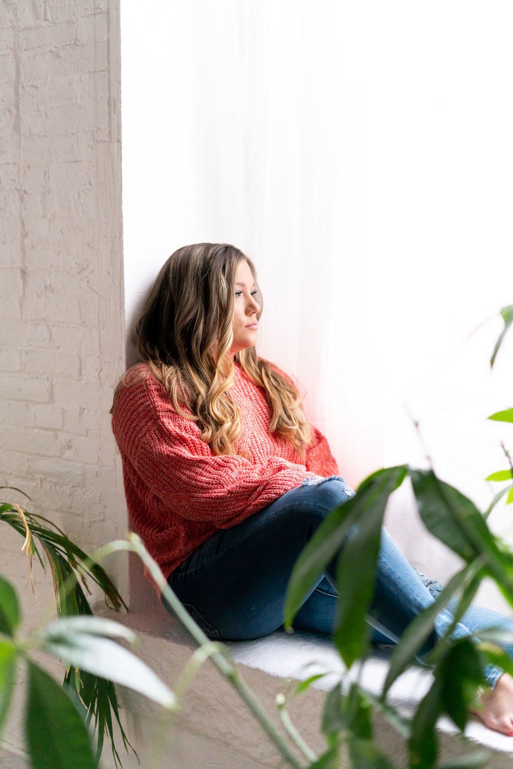 Ashley Marie seated thoughtfully beside a window